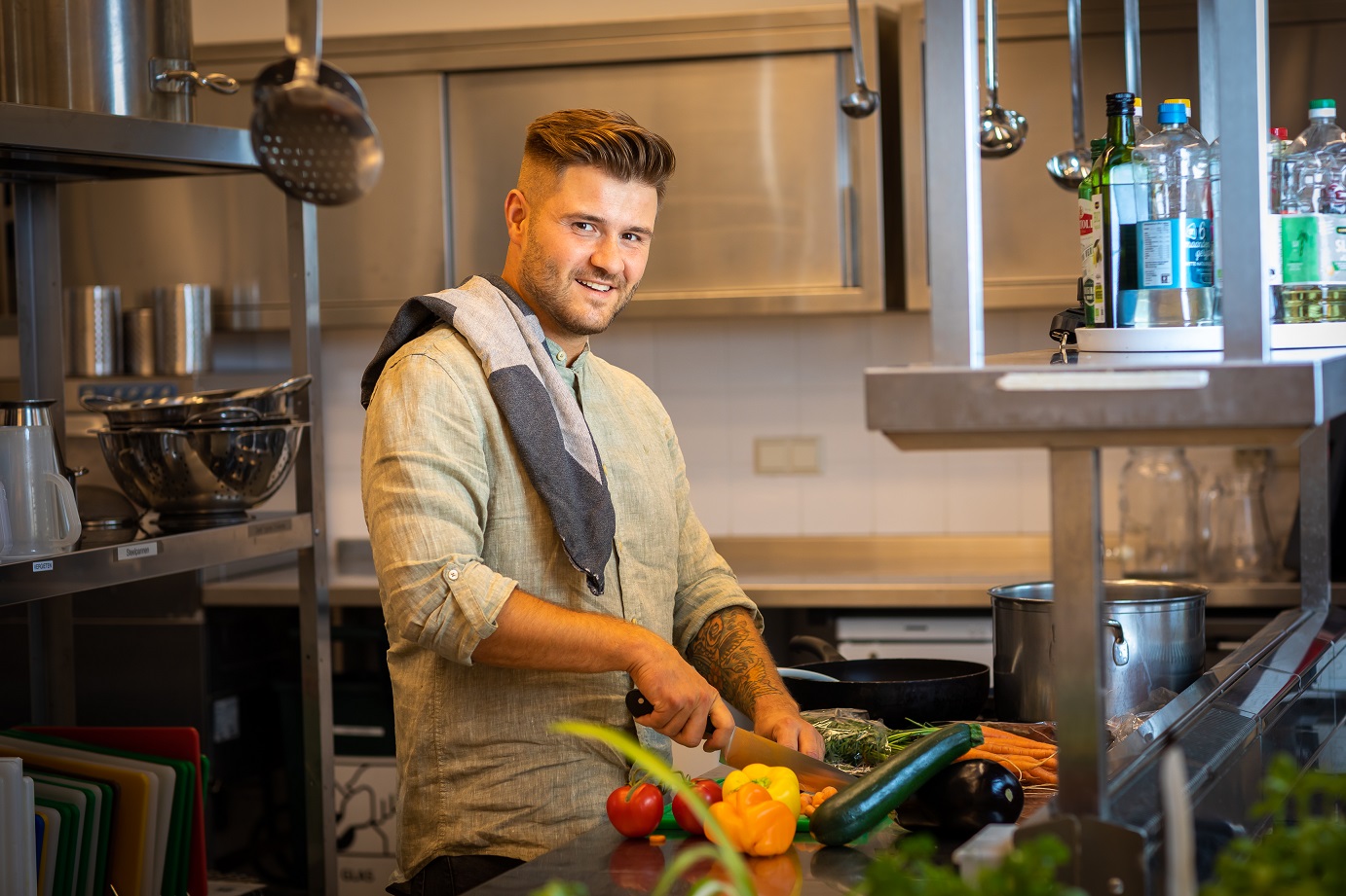 Jonge man bereidt eten in een keuken