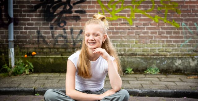 Jong meisje zit op de grond