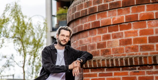 Jonge man leunt tegen muur