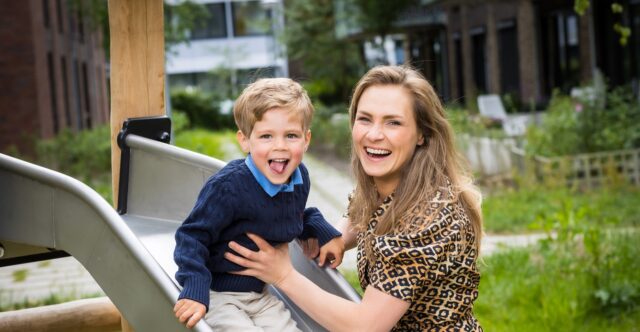 Moeder met zoontje op de glijbaan
