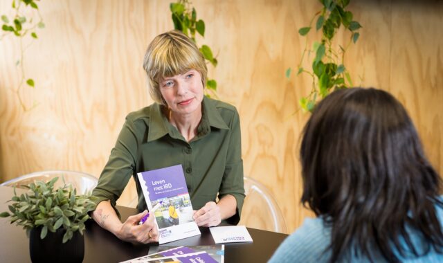 Vrouw laat onze brochure zien aan andere vrouw
